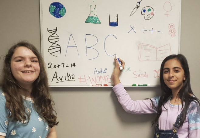 Two students in front of a whiteboard 